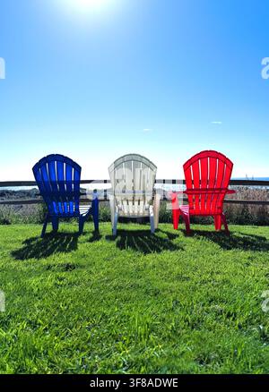 Sedie da giardino rosse, bianche e blu insieme viste da dietro. Foto Stock