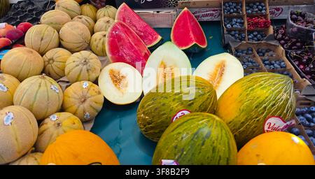 Meloni freschi di stagione e frutti estivi su un banco del mercato. Foto Stock