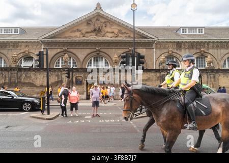 Agenti a cavallo della Polizia Metropolitana pattugliano vicino alle Royal Mews al Palazzo di Buckingham, a Londra, per mantenere la sicurezza pubblica per i turisti. Foto Stock