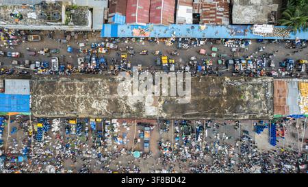 Vista aerea del vivace mercato di Fish Yard con numerose persone, bancarelle e casse di pesce sparse nel paesaggio urbano di Chittagong, Chittagong Foto Stock