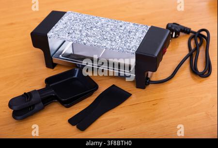 Grill da tavolo che serve piatti svizzeri di raclette Foto Stock