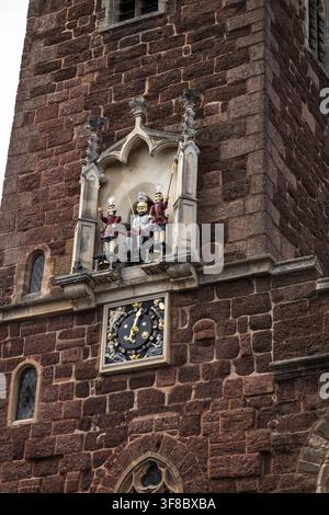 Vista del torre dell'orologio storica della chiesa di St Petrock con i quarter jacks decorati e il quadrante dell'orologio inseriti nel muratura in arenaria rossa a Exeter, E Foto Stock