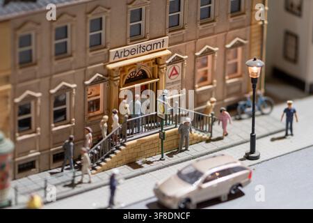 VIENA, AUSTRIA, 26 novembre 2022 : Un diorama stradale in miniatura dettagliato mostra piccole figure che entrano in un edificio contrassegnato Arbeitsamt accanto a un marciapiede, l Foto Stock