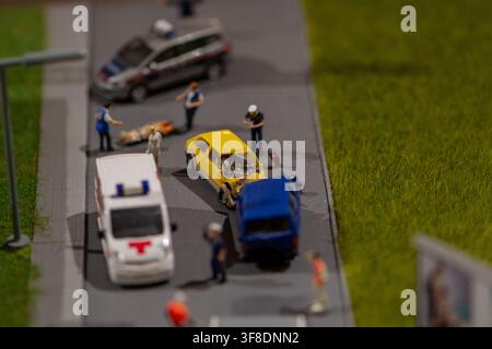 Un diorama in miniatura mostra veicoli di emergenza e soccorritori che intervengono su un incidente stradale che coinvolge un'auto gialla e un furgone blu. Foto Stock