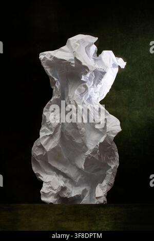 Carta bianca accartocciata su uno sfondo scuro Foto Stock