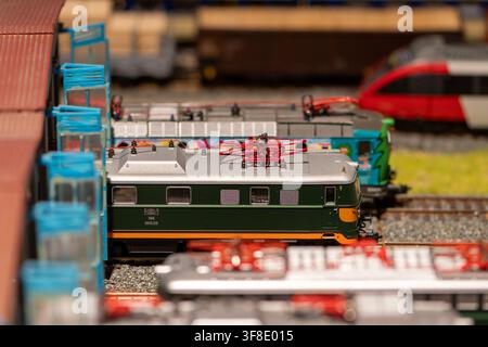 VIENNA, AUSTRIA, 26 novembre 2022: Un piano focale poco profondo in primo piano mostra diverse locomotive elettriche in miniatura posizionate sui binari accanto a un modello s Foto Stock