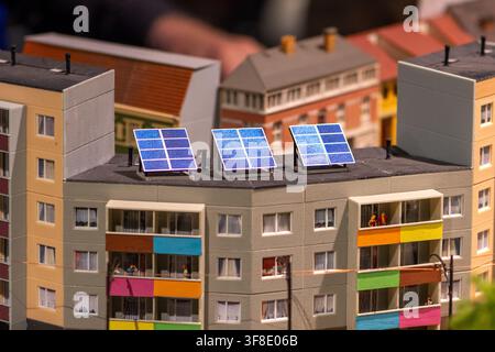 Una vista ravvicinata mostra un modello in scala di un blocco di appartamenti con pannelli solari sul tetto e balconi colorati. Foto Stock