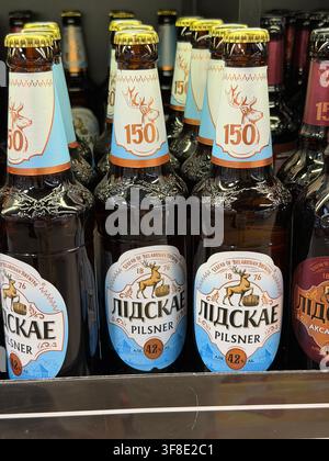 Vitsebsk, Bielorussia – 05 agosto 2026: Bottiglie di birra Lidskoye Pilsner esposte su uno scaffale, con etichette distinte e vari design di bottiglia Foto Stock