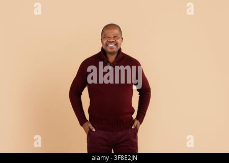 Uomo afroamericano maturo sorridente in piedi con sicurezza con le mani in tasca Foto Stock