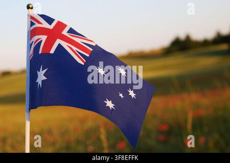 Bandiera australiana che sventola contro un cielo da campo al tramonto Foto Stock