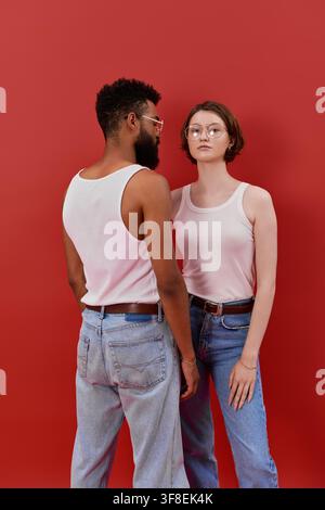Coppia elegante posa insieme, evidenziando il loro amore in un ambiente vivace. Foto Stock