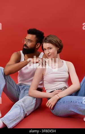 Una coppia multirazziale condivide un momento bellissimo, evidenziando il loro stile unico e il loro legame. Foto Stock