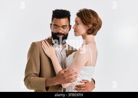 In un ambiente luminoso, una coppia chic condivide un momento tenero, celebrando il loro amore e unità. Foto Stock
