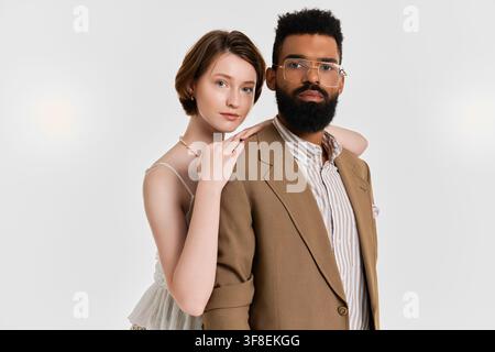 Una coppia abbraccia il proprio amore, sfoggiando abiti alla moda in un ambiente vivace. Foto Stock