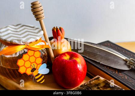 Simboli tradizionali della celebrazione di Rosh Hashanah, tra cui miele, mela, melograno e testi religiosi Foto Stock