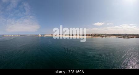 Vista aerea della spiaggia di Matosinhos con la sua costa sabbiosa, gli edifici urbani e le acque calme e blu dell'Oceano Atlantico a Matosinhos, Porto, Portogallo. Foto Stock
