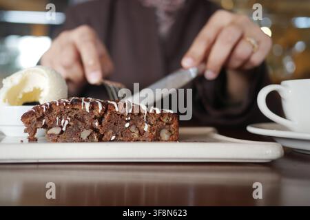 Mangiare un dessert con torta e gelato in un caffè Foto Stock