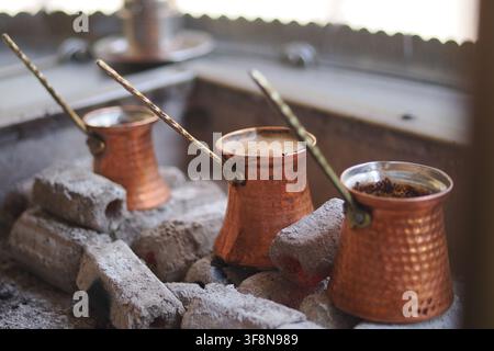 Pentole di rame riscaldate su pietre per preparare il caffè turco Foto Stock