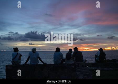 Galle, Sri Lanka - 01 maggio 2026: Vista di persone sedute sulle mura storiche del forte olandese di Galle che osservano il tramonto sull'Oceano Indiano. Foto Stock