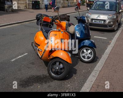 Due scooter Vespa classici parcheggiati su High Street, Stony Stratford, Buckinghamshire, Regno Unito Foto Stock