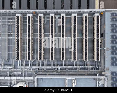 Tetto di un data center con più unità di raffreddamento, sistemi di ventilazione, tubi e pannelli solari per un'energia sostenibile Foto Stock
