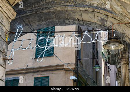 Insegna LED illuminata che spelling Fugassa sotto l'arco storico in pietra Cinque Lampadi all'ingresso di Via di Canneto il Curto, Genova, Italia. Foto Stock