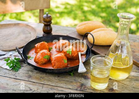 Polpette fritte brasate in salsa di pomodoro servite in giardino. Mangiare polpette arrosto di manzo in salsa di pomodoro. Foto Stock