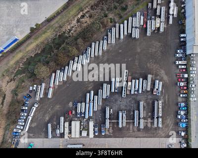 Rimorchi e veicoli parcheggiati in un deposito logistico industriale Foto Stock