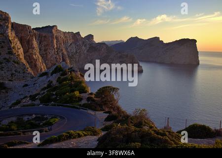 Strada di montagna sinuosa e panoramica che si affaccia su drammatiche scogliere a picco e il mare al tramonto al Cap de Formentor a Maiorca, Spagna Foto Stock