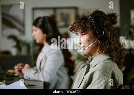 Diverse operatrici donne che lavorano in un call center di assistenza clienti Foto Stock
