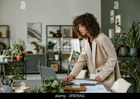 Giovane donna che lavora su un laptop in un ufficio moderno Foto Stock