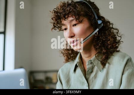 Donna che lavora in un call center fornendo assistenza clienti Foto Stock