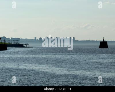 Colegiales, Buenos Aires, Argentina – 31 marzo 2026: Una vista panoramica del fiume con una lontana skyline cittadina e una struttura silouettata prominente. Foto Stock