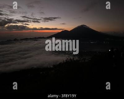 Monte Batur, montagna vulcanica che si erge sopra il mare di nuvole all'alba, visto dal Monte Batur, Banjar Kedisan, Bali, Indonesia Foto Stock