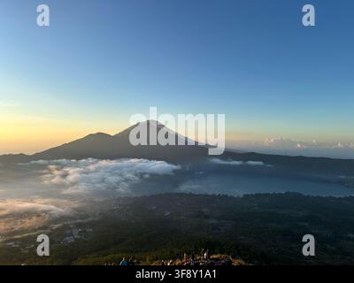 Banjar Kedisan, Bali, Indonesia - 19 luglio 2024: Vista del monte Agung con mare di nuvole all'alba dal monte Batur Foto Stock