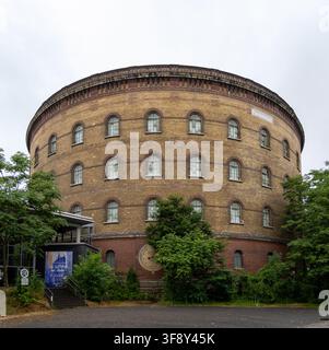 Vista esterna dell'edificio circolare storico in mattoni del Panometer di Lipsia a Lipsia, Sassonia, Germania, circondato da alberi sotto un cielo nuvoloso. Foto Stock