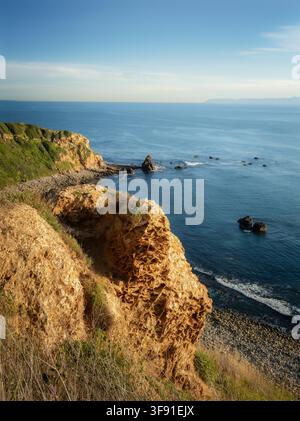 Scogliere costiere dorate che si affacciano sull'oceano Pacifico blu lungo la costa frastagliata della California. Foto Stock