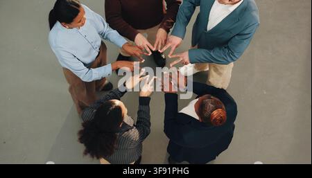 Affari, persone e riunione con segno zodiacale per collaborazione, unità o solidarietà di squadra. Vista dall'alto, gruppo o dipendenti con forma, mani o dita Foto Stock