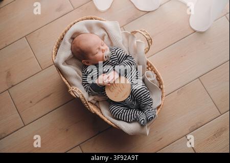 Neonato che dorme pacificamente in un cesto con un cartello con la scritta "ciao mondo" Foto Stock