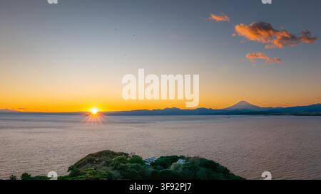 Panorama mozzafiato del tramonto sull'oceano con l'isola di Enoshima in primo piano e il Monte Fuji in lontananza a Kanagawa, Giappone. Foto Stock