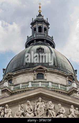 La cupola di rame della Basilica di Santo Stefano si erge sopra un rilievo scolpito sul frontone che raffigura figure incoronate che presentano doni a una Madonna assisa sul trono Foto Stock