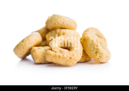 Un primo piano di una pila di taralli dorati, tradizionali biscotti italiani a forma di anello, fotografati su sfondo bianco. Spuntino croccante e saporito perfetto per antipasti, tavole di antipasti e snack informali. Foto Stock