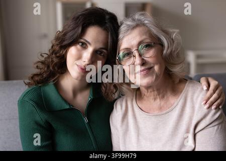 Giovane figlia adulta in posa per un ritratto con la madre anziana Foto Stock