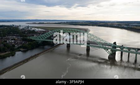 Vista aerea del ponte del Giubileo d'Argento che attraversa il fiume Mersey con dintorni urbani e acque calme a Runcorn, Regno Unito. Foto Stock