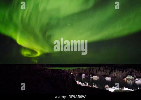 Aurore boreale verde che risplende sopra un lodge sul lago a Yellowknife, Territori del Nord-Ovest, Canada Foto Stock