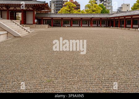 Una vasta veduta del cortile di ghiaia circondato dalla galleria tradizionale Kairo e dal cancello Chumon al tempio Shitennoji di Osaka, Giappone. Foto Stock
