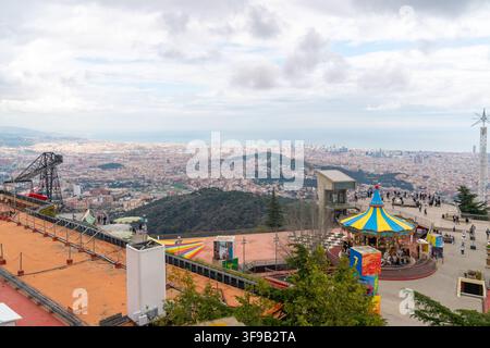 Barcellona, Spagna - 11 marzo 2025: Una vasta veduta cattura l'ampia città di Barcellona e il Mar Mediterraneo dall'elevato parco divertimenti di Tibidabo Foto Stock