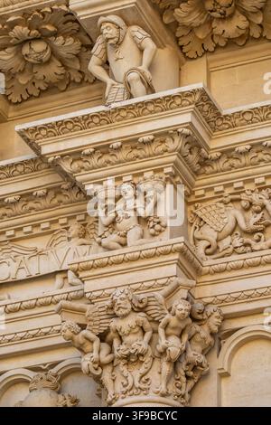Dettagliati intagli barocchi in pietra sulla facciata della Basilica di Santa Croce a Lecce, Italia Foto Stock