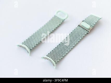 Due cinturini per orologio in maglia verde menta sono esposti su una superficie bianca Foto Stock