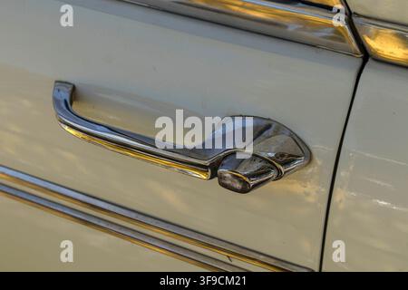 Tavernes Blanques, Spagna – 14 giugno 2026. L'immagine mostra un primo piano di una maniglia della porta cromata e di una modanatura laterale metallica su una berlina classica Seat. L'auto Foto Stock